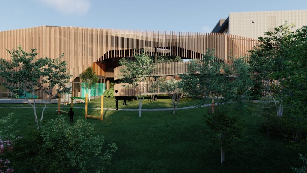 Fachada da unidade infantil da Coree International School, com muitos elementos de madeira e um amplo gramado